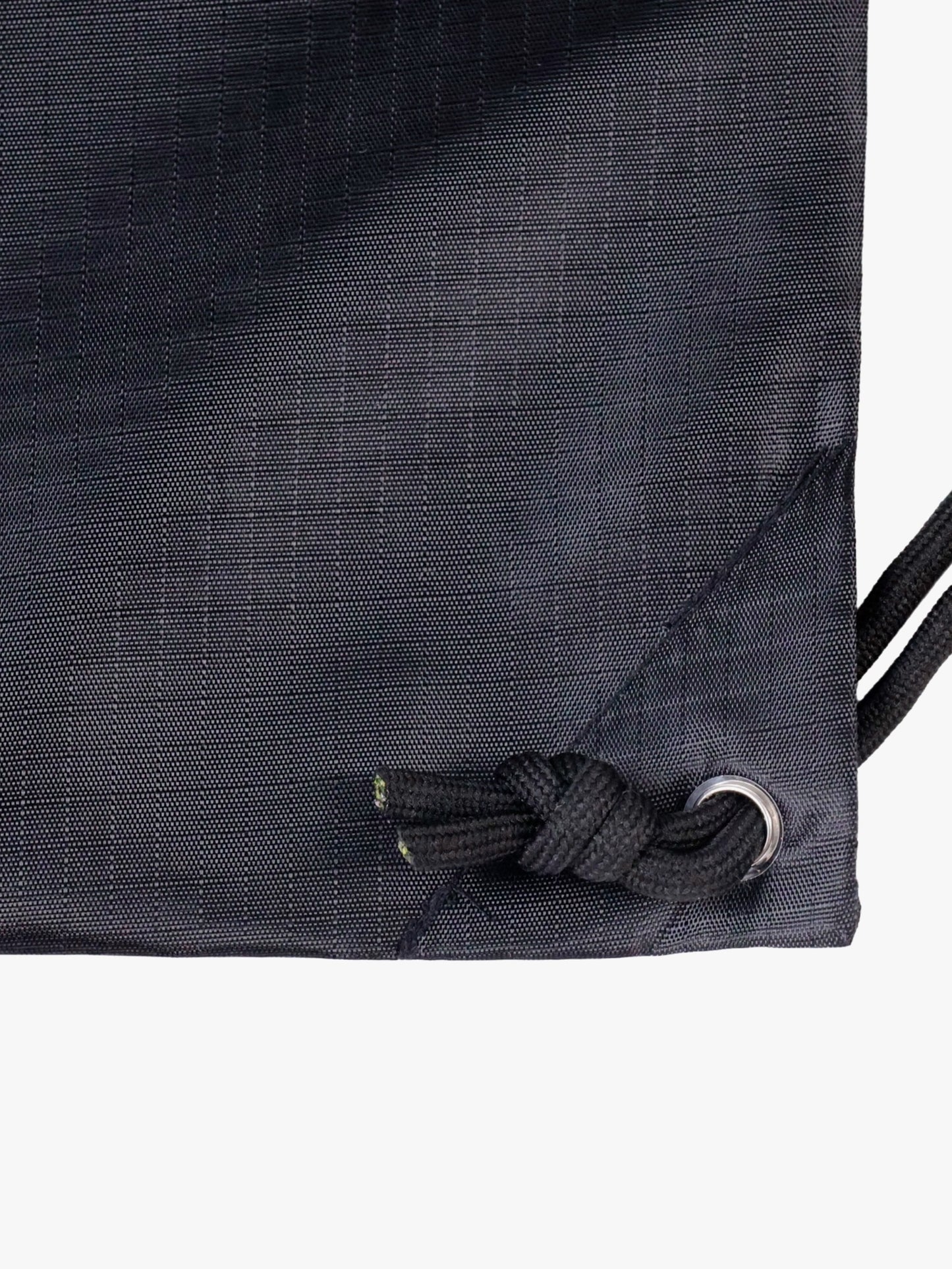 Close-up detail of the Myo+ drawstring gym bag showing the reinforced metal grommet, knotted drawstring tie-off, and ripstop nylon fabric