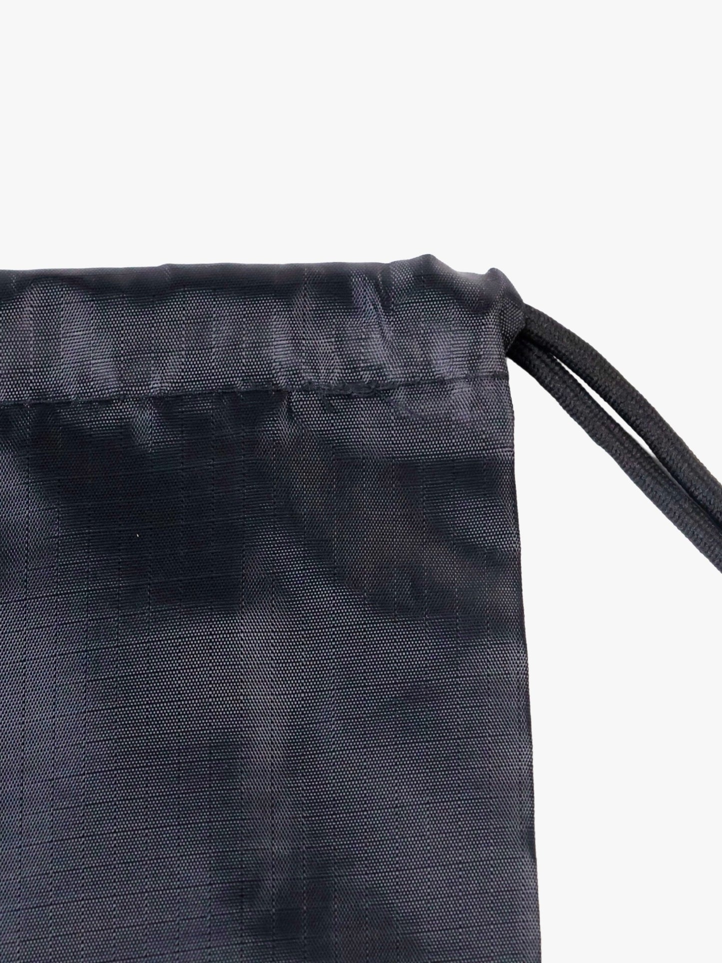 Close-up of the Myo+ drawstring gym bag top hem showing the drawstring channel, reinforced stitching, and cord exit point in matte black ripstop nylon
